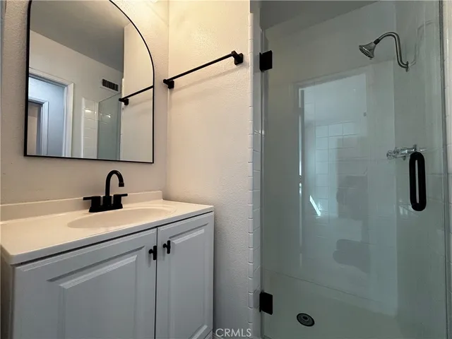 a view of a bathroom sink a mirror and shower