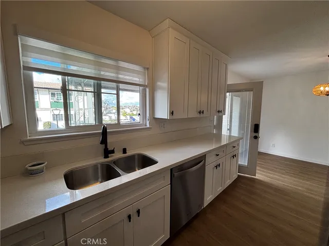 a kitchen with stainless steel appliances granite countertop a sink and a wooden floors