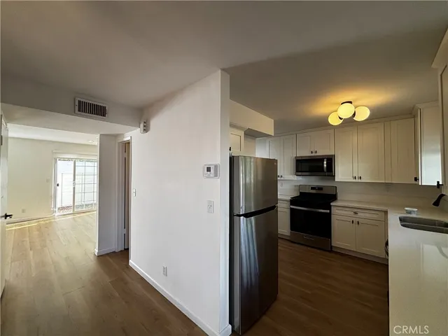 a kitchen with stainless steel appliances a refrigerator and a stove top oven
