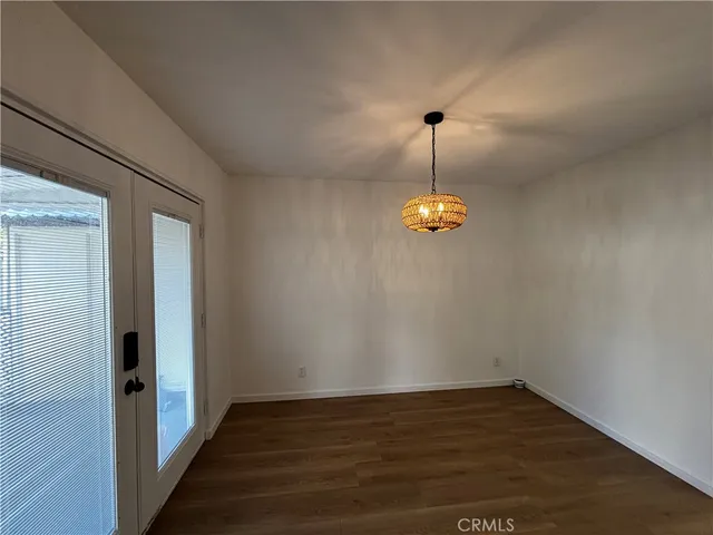 a view of a room with wooden floor and white walls