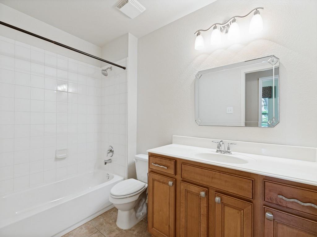 10032 Bell Rock Road Frisco, TX 75035 - Photo 9 of 23 Bathroom featuring white subway tile tub surround, a white porcelain tub, and a toilet.