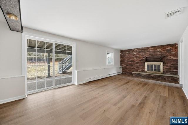 373 West Saddle River Road Upper Saddle River, NJ 07458 - Photo 26 of 31 an empty room with wooden floor and fireplace