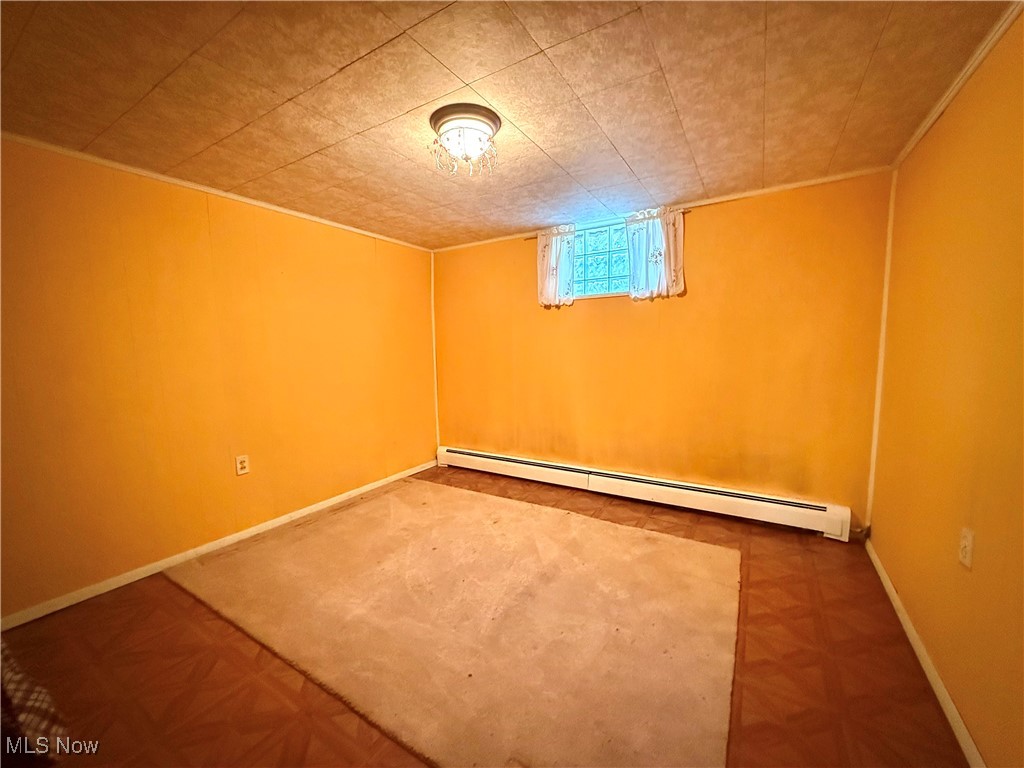 4878 Wylie Ridge Road New Cumberland, WV 26047 - Photo 13 of 20 Below grade area featuring a baseboard heating unit and baseboards