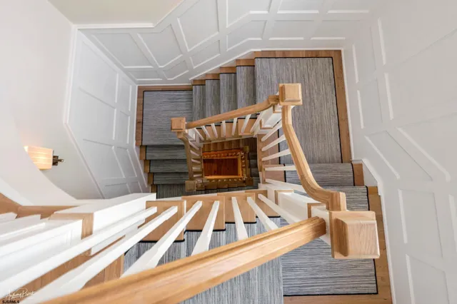 a large white kitchen with granite countertop a sink and dishwasher a stove top oven with wooden floor