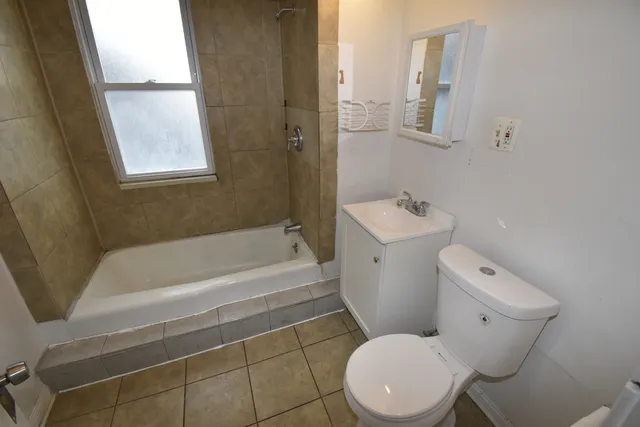 a white toilet sitting next to a bath tub