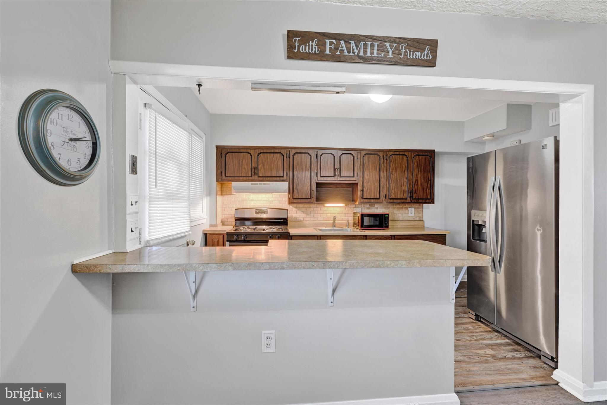 2013 Wareham Road Baltimore, MD 21222 - Photo 6 of 17 a kitchen with stainless steel appliances granite countertop a refrigerator a stove and a sink with wooden floor