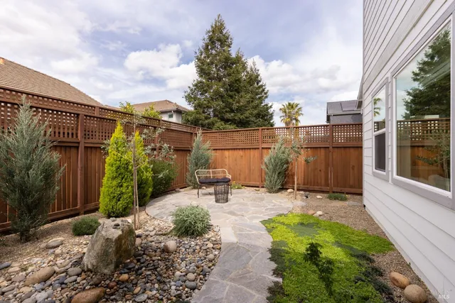 a view of a chair and table in backyard of the house