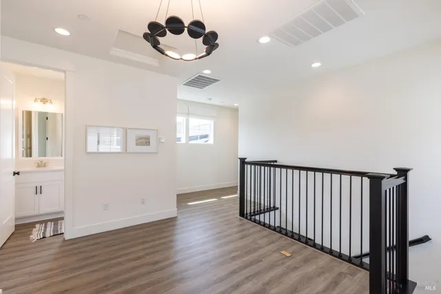 a view of a hallway with wooden floor and a chandelier