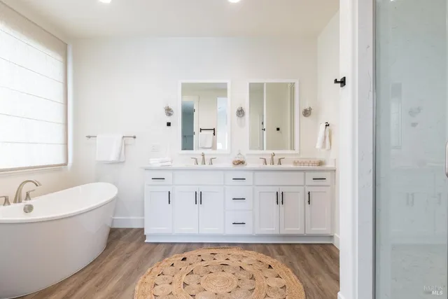 a bathroom with a granite countertop sink and a bathtub