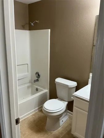 a white toilet sitting next to a bath tub