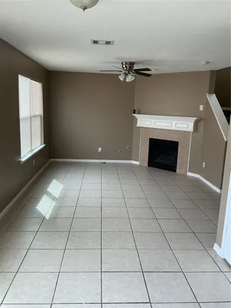 a view of an empty room with a fireplace and a window