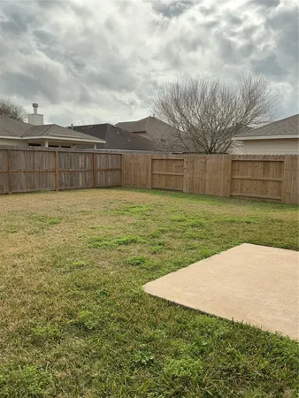 a view of a yard with wooden fence