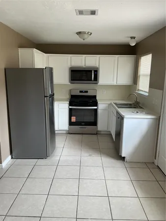 a kitchen with a stove a microwave and a refrigerator