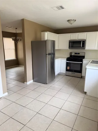 a kitchen with stainless steel appliances a refrigerator and a stove top oven