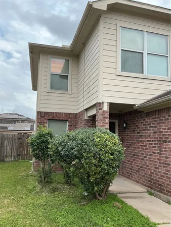 a brick house with a small yard and plants