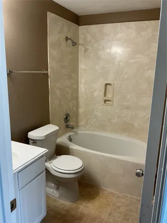 a white toilet sitting next to a bath tub