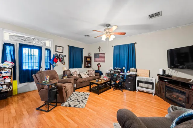 a living room with furniture kitchen view and a flat screen tv