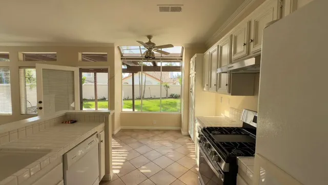 a kitchen with kitchen island granite countertop a refrigerator a sink and a stove