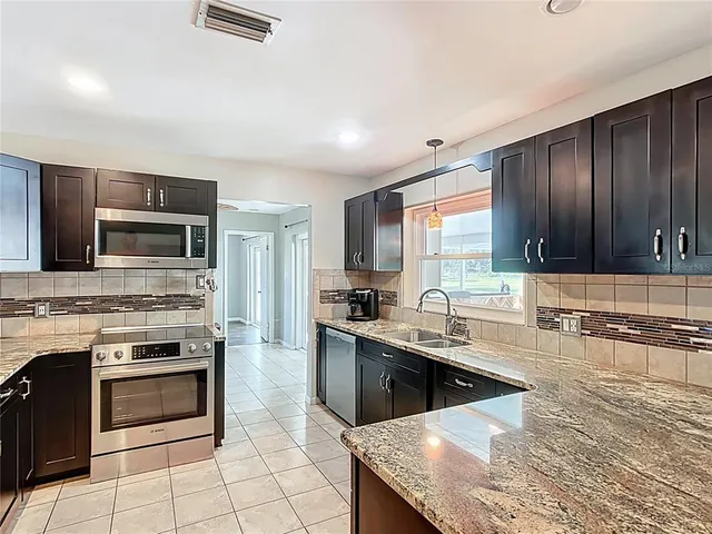 a kitchen with a stove sink and microwave