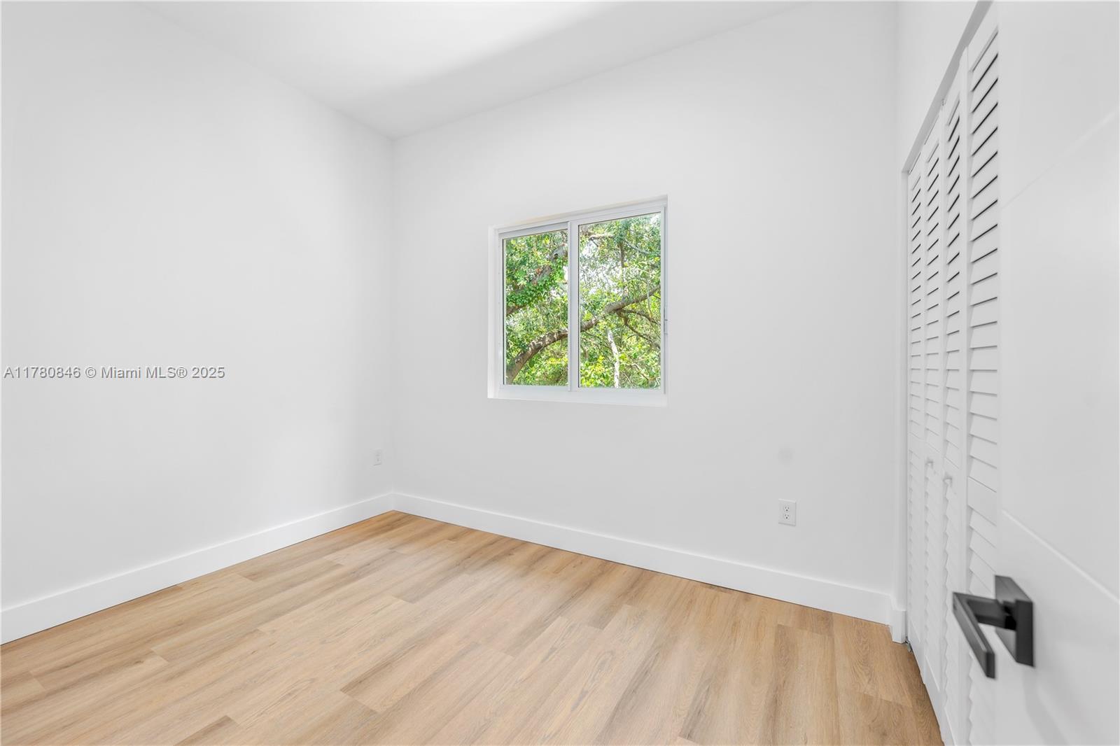2121 Northwest 45th Street, Unit 2123 Miami, FL 33142 - Photo 17 of 24 a view of an empty room with wooden floor and a window