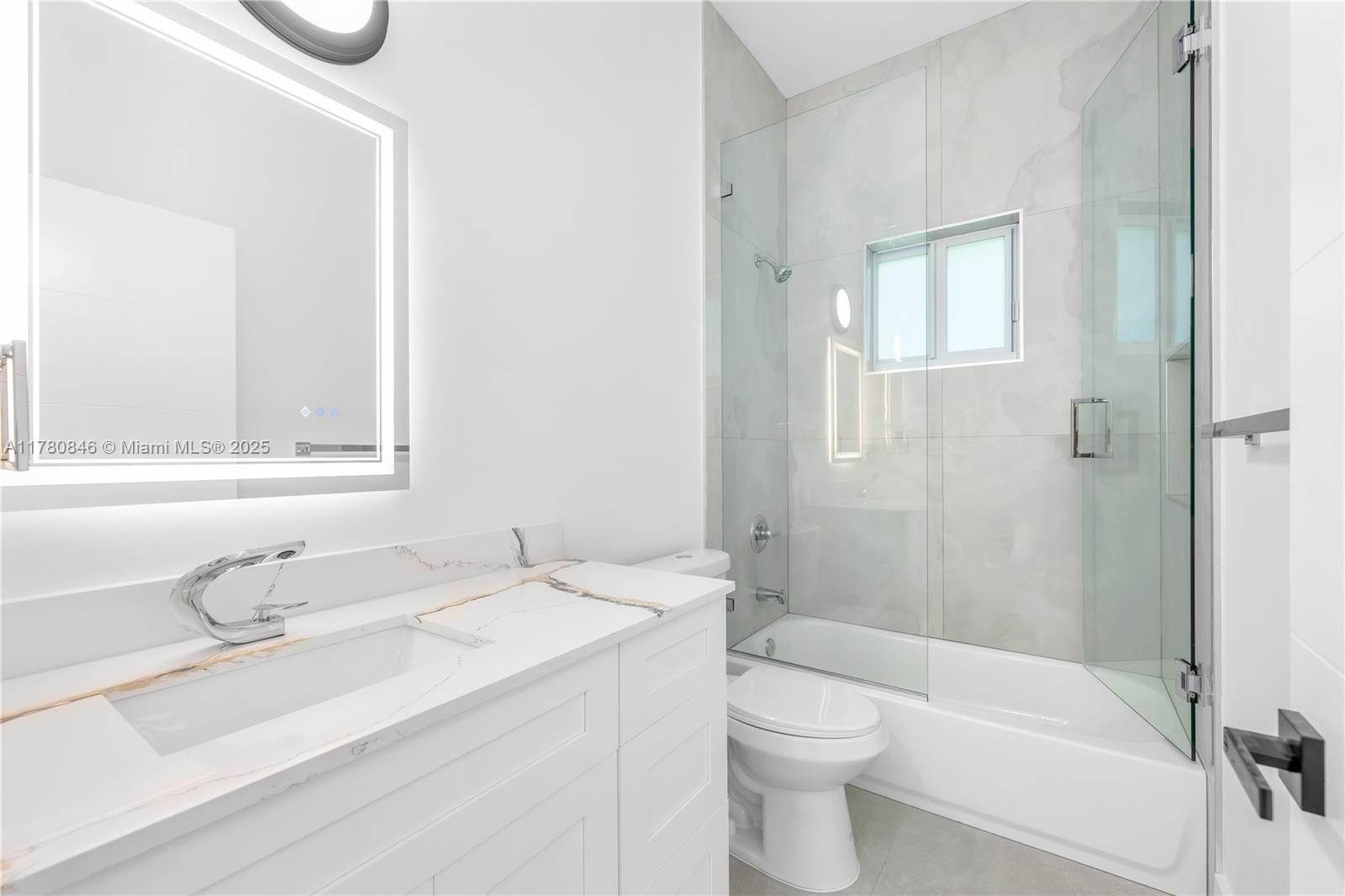 2121 Northwest 45th Street, Unit 2123 Miami, FL 33142 - Photo 18 of 24 a bathroom with a granite countertop sink toilet and shower
