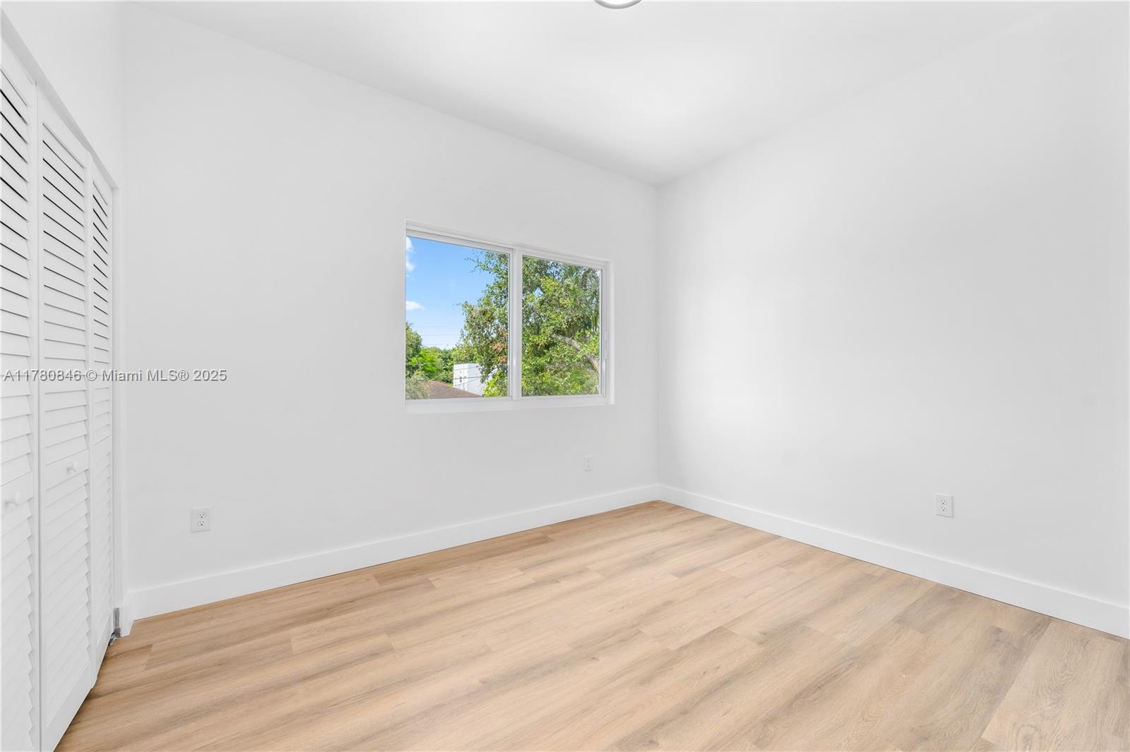 2121 Northwest 45th Street, Unit 2123 Miami, FL 33142 - Photo 19 of 24 an empty room with wooden floor and window