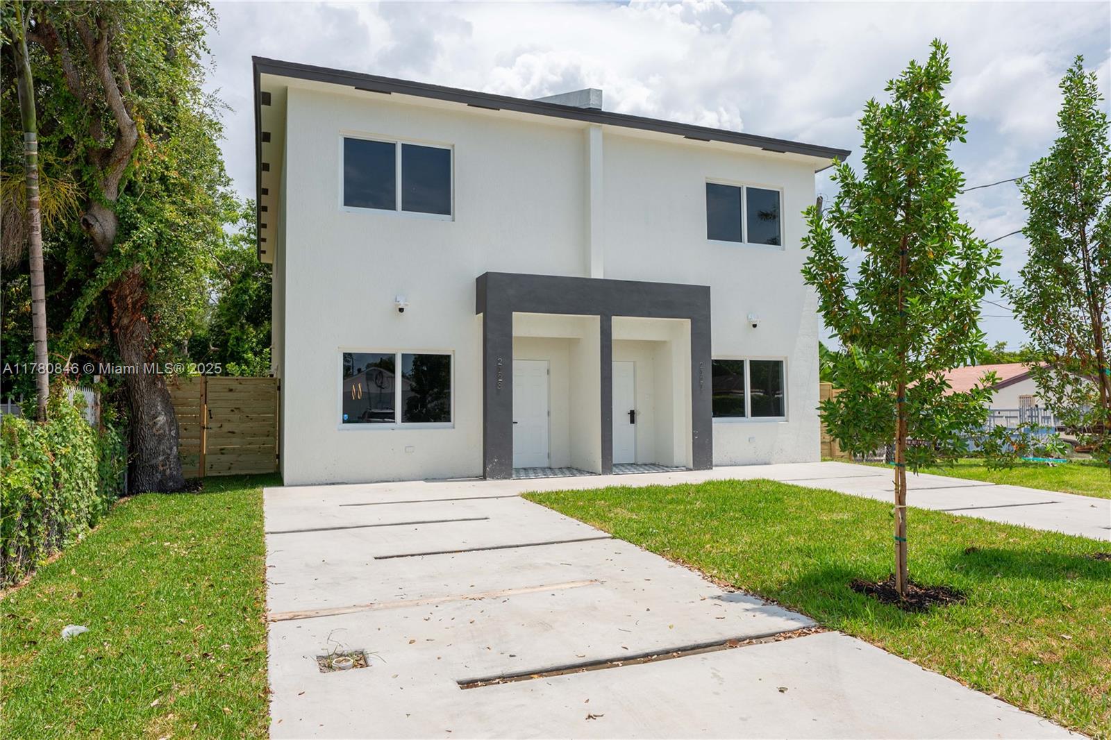 2121 Northwest 45th Street, Unit 2123 Miami, FL 33142 - Photo 24 of 24 a front view of a house with a yard and trees