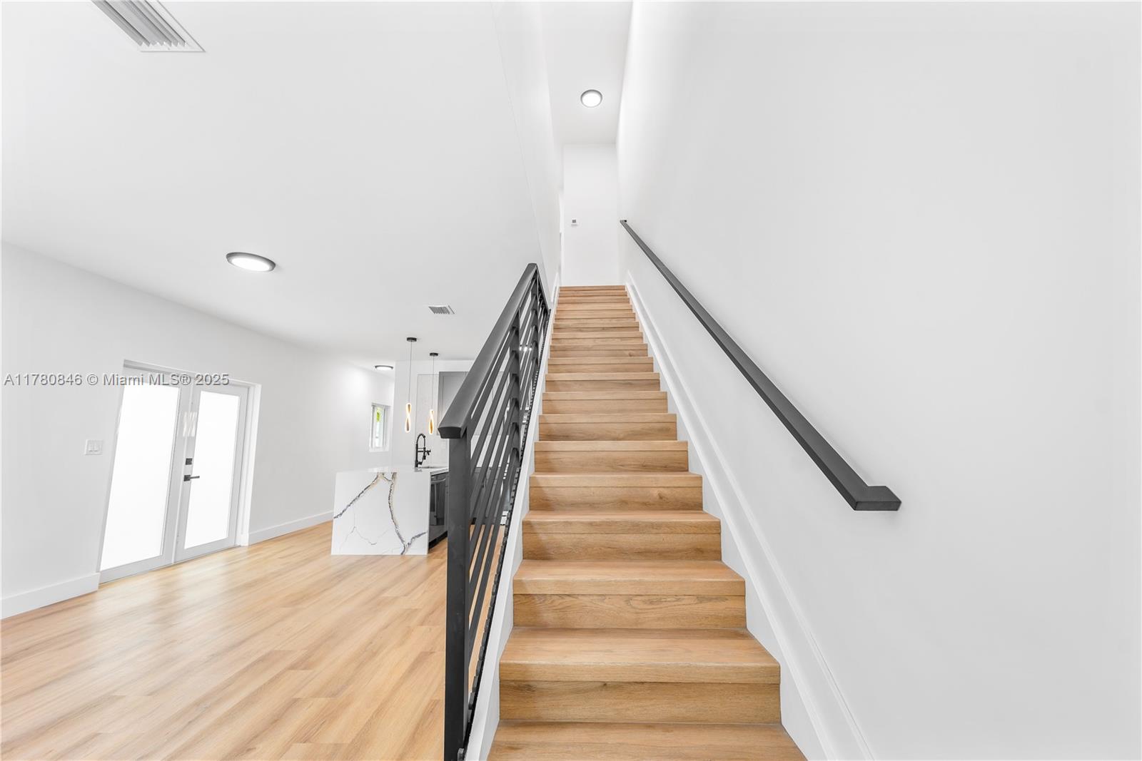 2121 Northwest 45th Street, Unit 2123 Miami, FL 33142 - Photo 4 of 24 a view of staircase with wooden floor and white walls