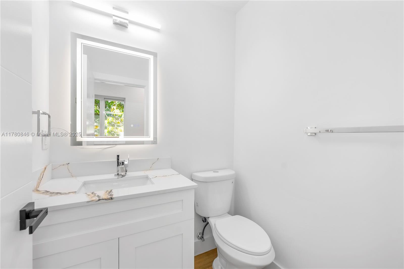 2121 Northwest 45th Street, Unit 2123 Miami, FL 33142 - Photo 8 of 24 a bathroom with a sink mirror vanity and toilet