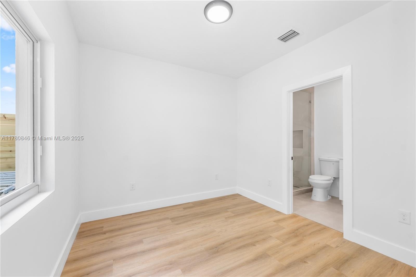 2121 Northwest 45th Street, Unit 2123 Miami, FL 33142 - Photo 9 of 24 a big room with wooden floor and windows