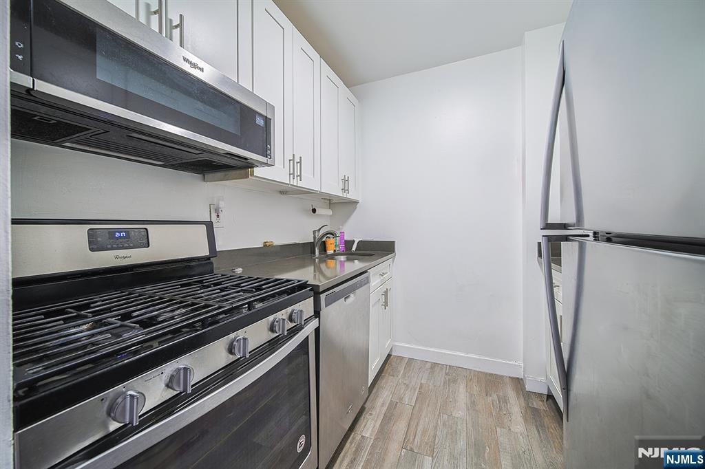 277 Prospect Avenue, Unit 4A Hackensack, NJ 07601 - Photo 17 of 27 a stove top oven sitting inside of a kitchen