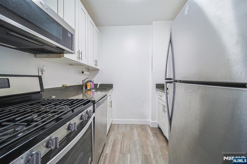 277 Prospect Avenue, Unit 4A Hackensack, NJ 07601 - Photo 18 of 27 a kitchen with a stove and a refrigerator