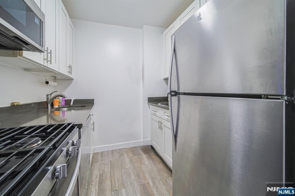 277 Prospect Avenue, Unit 4A Hackensack, NJ 07601 - Photo 19 of 27 a kitchen with a refrigerator and a stove