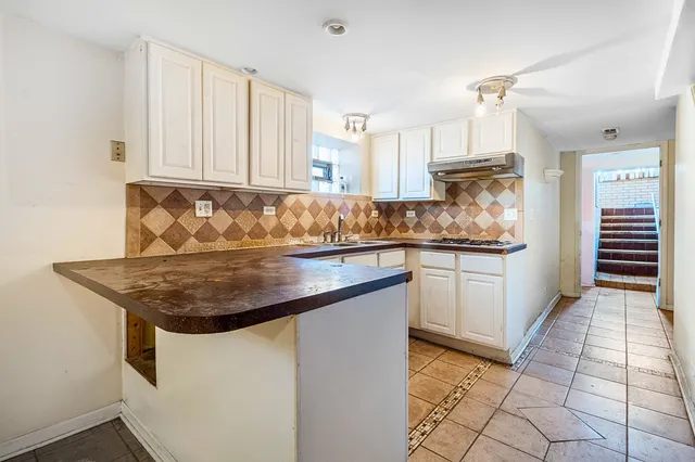 a kitchen with stainless steel appliances granite countertop a sink and dishwasher with white cabinets