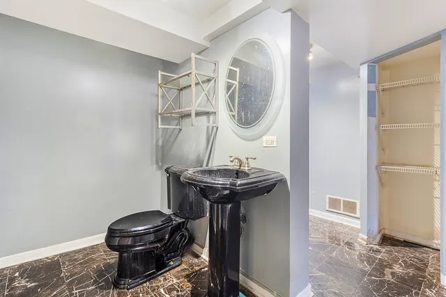 a bathroom with a sink a toilet and a mirror