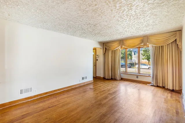 an empty room with wooden floor and sliding door