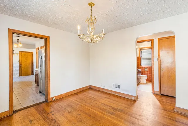 a view of a room with wooden floor and a ceiling fan