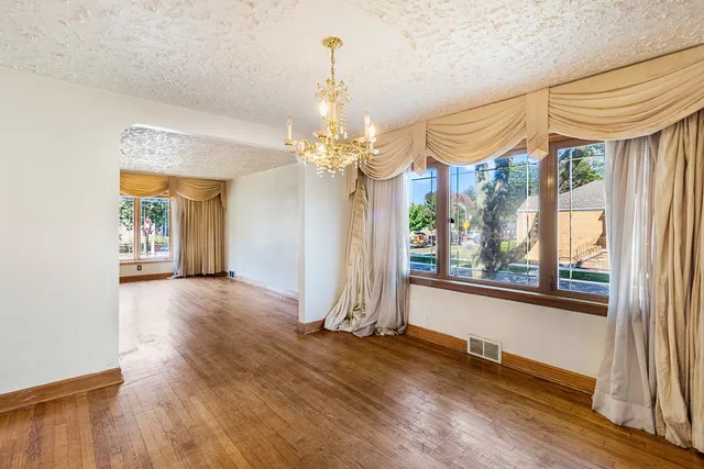 a view of a room with wooden floor and windows