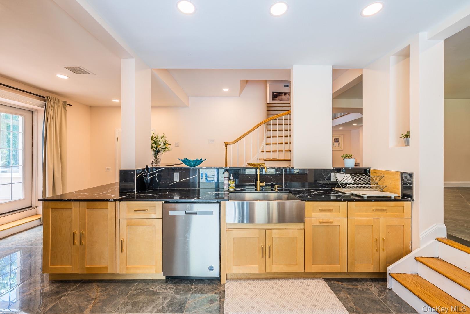 530 South Centre Island Road Centre Island, NY 11771 - Photo 13 of 32 Kitchen with stainless steel dishwasher, dark stone counters, light brown cabinets, recessed lighting, and tasteful backsplash