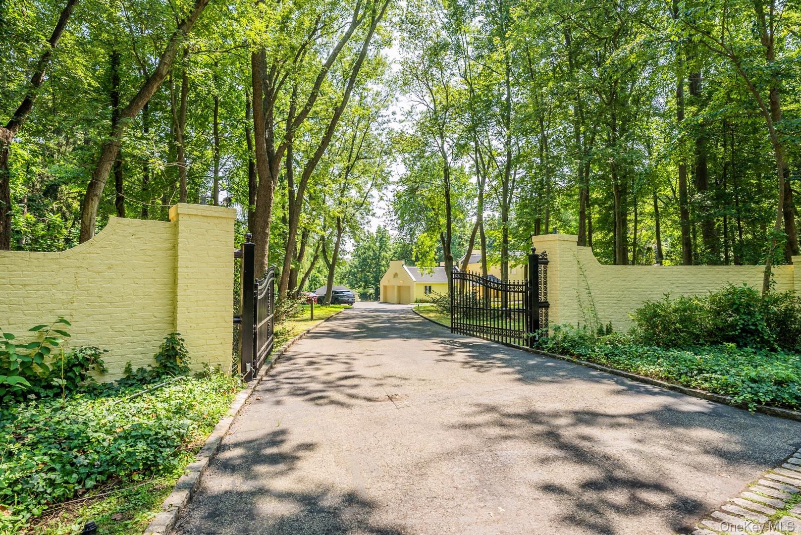 530 South Centre Island Road Centre Island, NY 11771 - Photo 2 of 32 View of asphalt driveway with a gate, a gated entry, and view of scattered trees
