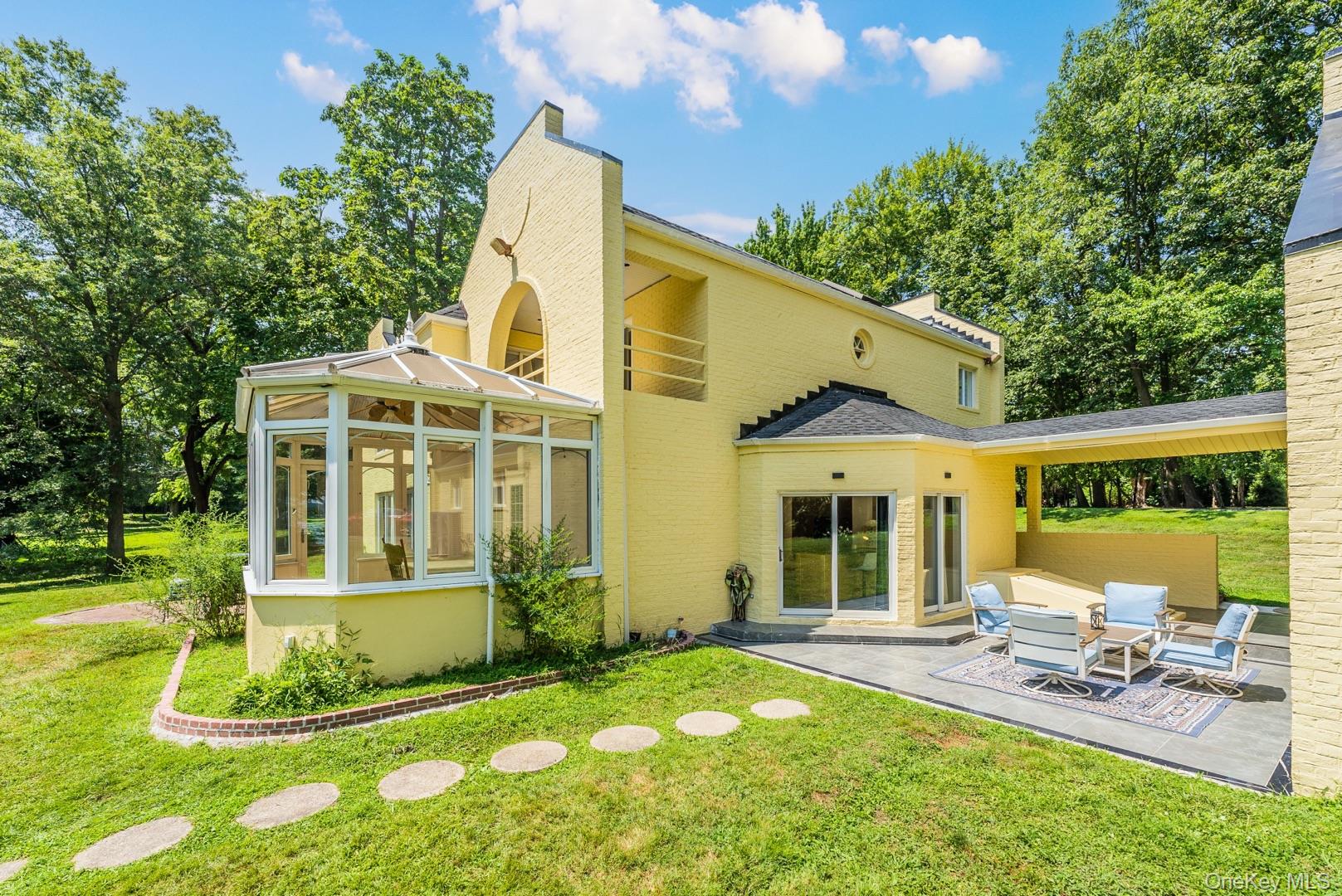 530 South Centre Island Road Centre Island, NY 11771 - Photo 5 of 32 Back of property featuring a sunroom, a lawn, a patio, and view of scattered trees