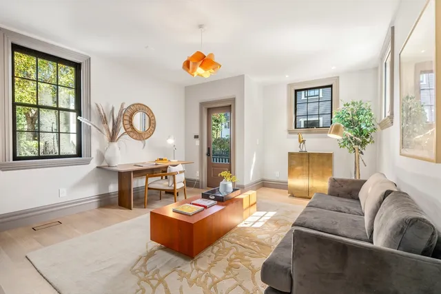 a living room with fireplace furniture and a large window