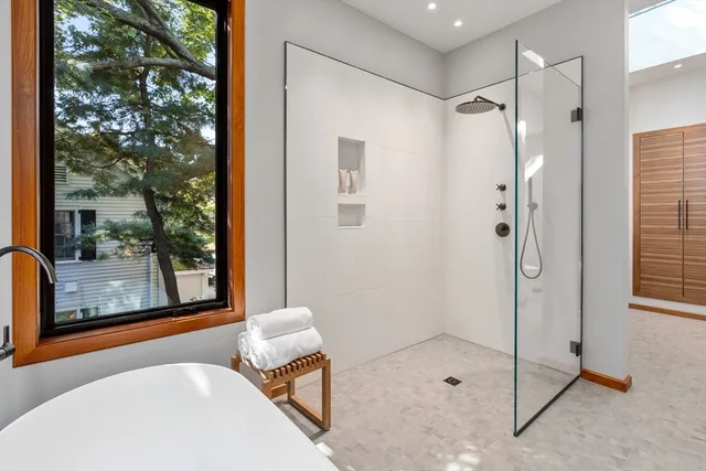 a spacious bedroom with a bed a table and chair with the potted plants