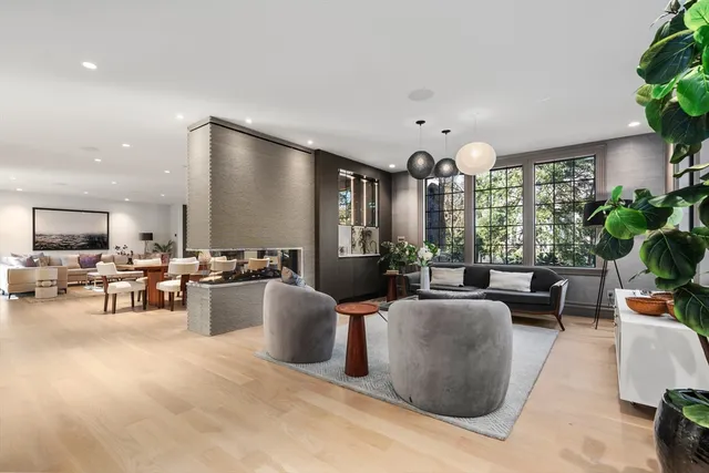 a living room with furniture kitchen view and large windows