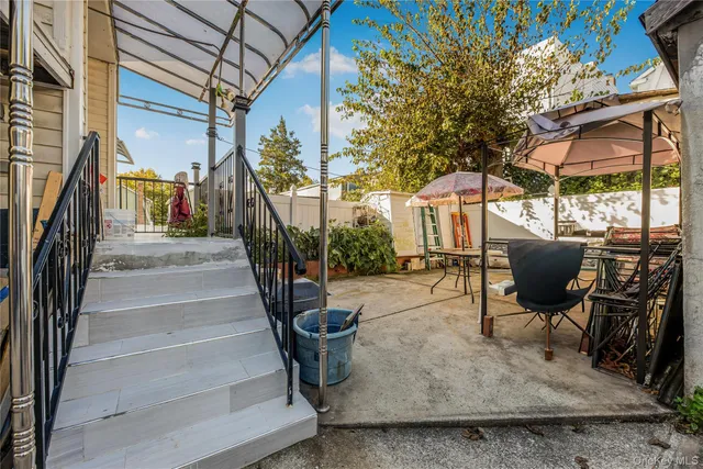 a view of a patio with table and chairs under an umbrella