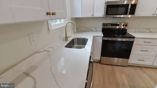 a kitchen with a sink a stove and cabinets