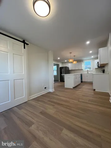 a view of kitchen and hall with wooden floor