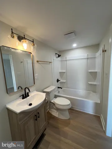 a bathroom with a double vanity sink toilet mirror and shower