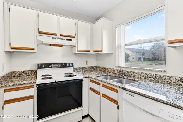 an empty room with closet and a chandelier fan