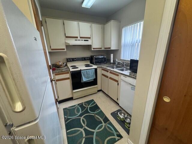 240 Spring Drive, Unit 5 Merritt Island, FL 32953 - Photo 5 of 17 a kitchen with stainless steel appliances granite countertop a stove a sink and a refrigerator